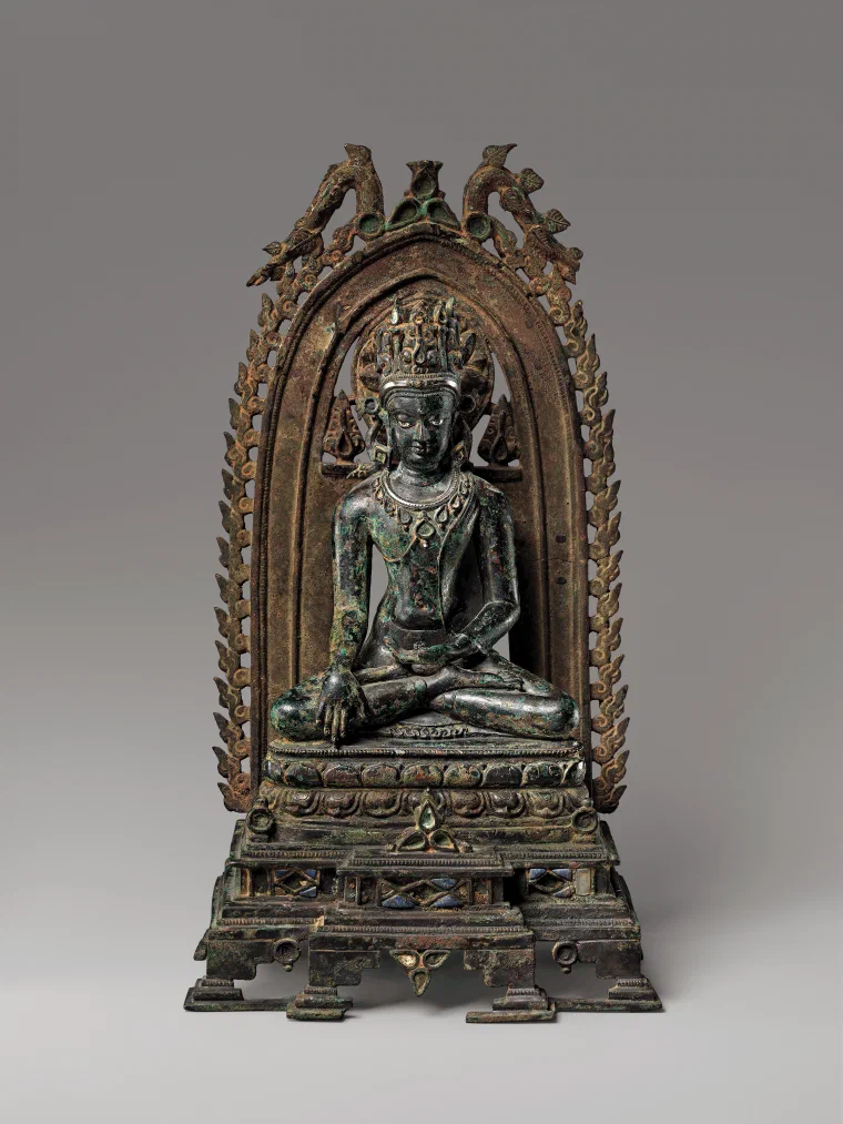 Bronze seated Buddha wearing a jeweled crown inside a flame-edged arched shrine