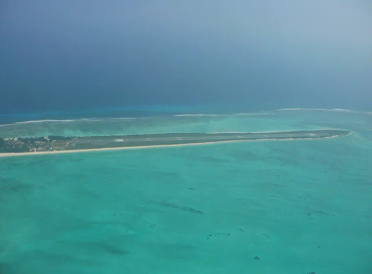 Aerial view of the narrow green island of Agatti between a turquoise lagoon and the deep blue Arabian Sea