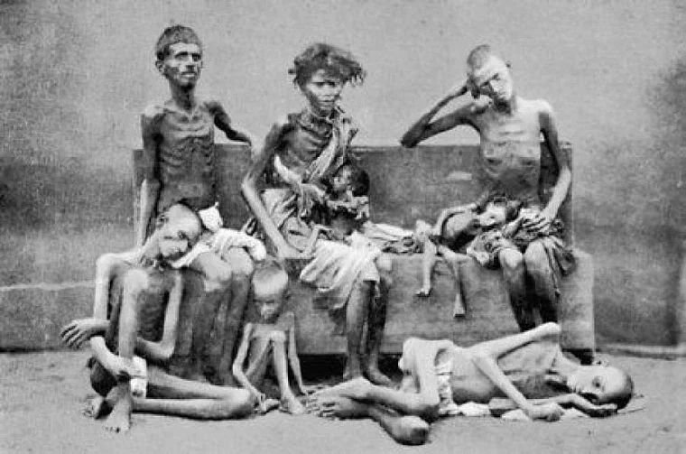 Photograph from the late 1870s of emaciated men, women and children seated on the ground at a famine relief camp in Madras Presidency