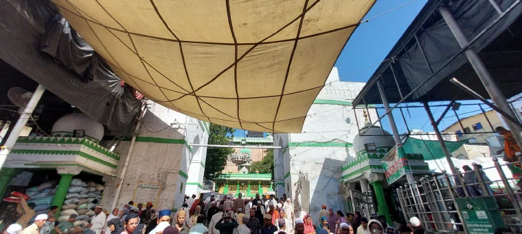 Pilgrims moving through the crowded white marble courtyard of the Ajmer Sharif dargah in Rajasthan